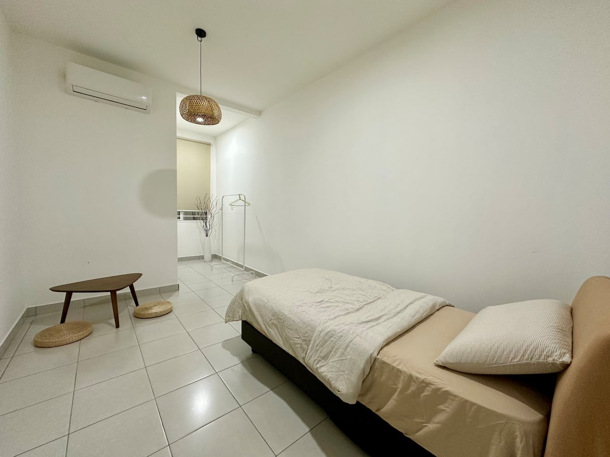 Bedroom with a low table and floor cushions beside the bed