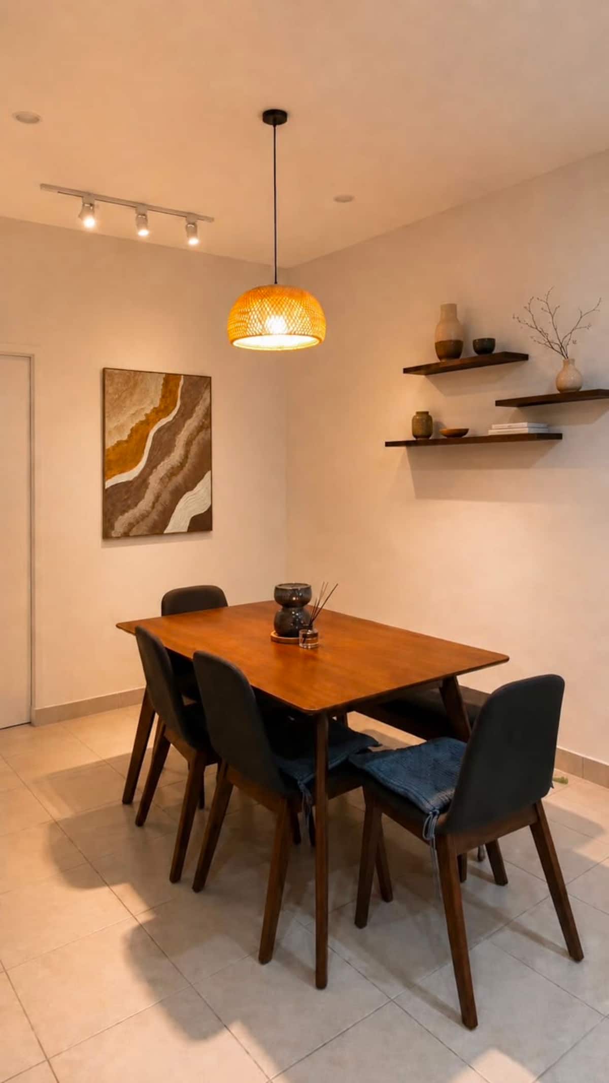 Dining area with a wooden table, four dark chairs and a pendant lamp